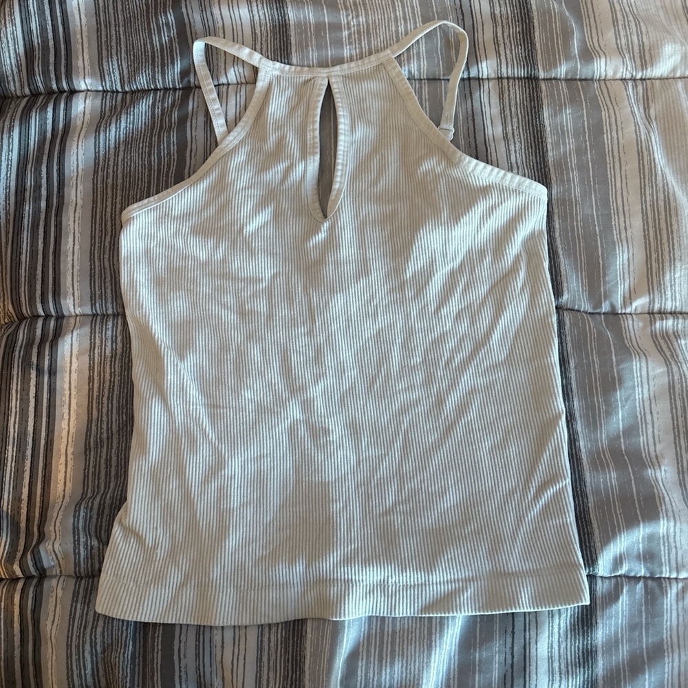 white, cropped tank top, oval cutout on chest area, cross over design in back